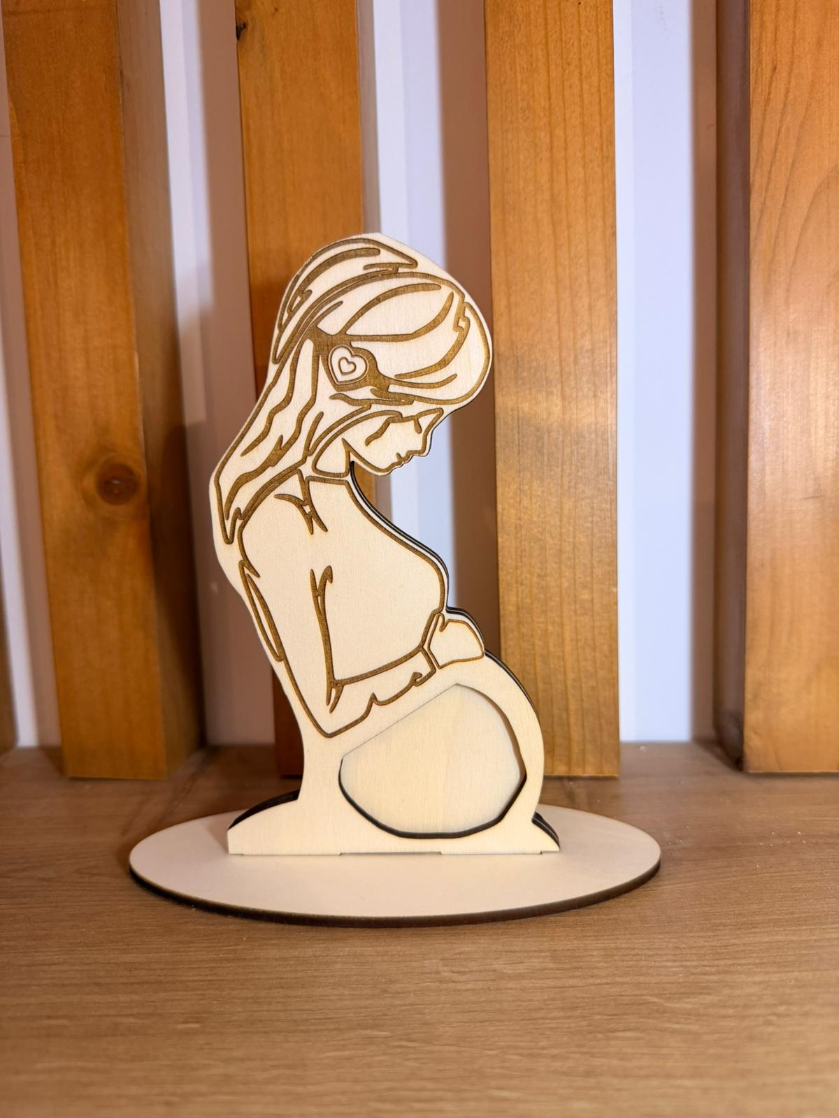 Siluetă de femeie însărcinată decupată într-o ramă din lemn